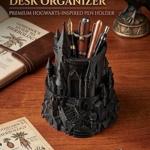 May include: Black desk organizer shaped like a castle, holding pens. The text on the image reads "WIZARD'S DESK ORGANIZER" and "PREMIUM HOGWARTS-INSPIRED PEN HOLDER". A book titled "GOSHAWK'S GUIDE TO HERBOLOGY" is also visible.