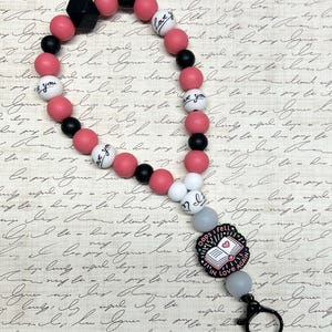Page-Turner Wristlet for Kindle / iPad / E-Reader. Silicone Pink, Black Book Lover Oops!
