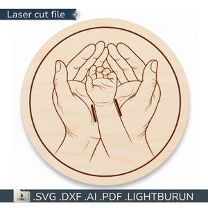 May include: A round wooden laser cut file featuring a detailed illustration of adult hands cradling a baby's hand. The design is in a minimalist style with dark brown outlines on a light wood background. The text "Laser cut file" is at the top.