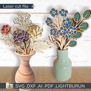 May include: Two vases with wooden laser-cut flowers. One vase is peach and white, the other is green. The flowers are various colors, including red, purple, yellow, and blue. The text "Laser cut file" is in the top left corner.