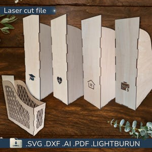 May include: Wooden laser-cut file organizers with decorative cutouts and engraved icons. The organizers include a graduation cap, a heart, a house, and a briefcase with a dollar sign. The text "Laser cut file" is at the top. File formats include .SVG, .DXF, .AI, .PDF, and .LIGHTBURN.