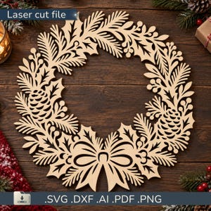 Può includere: Una ghirlanda in legno chiaro tagliata al laser con motivi complessi di aghi di pino, foglie di agrifoglio, pigne e un fiocco centrale in basso. Il testo Laser cut file è presente in alto e SVG DXF AI PDF PNG in basso.