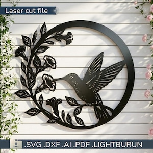 May include: Black metal hummingbird wall art with a floral design, laser cut from metal. The hummingbird is depicted with outstretched wings, feeding from a flower. The text "Laser cut file" is at the top. The file formats are listed at the bottom.
