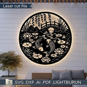 Peut inclure: Une décoration murale circulaire en métal noir présentant une découpe laser de deux poissons koï nageant dans un étang avec des fleurs de lotus, des nénuphars et un pont voûté. L'œuvre est rétroéclairée, créant un halo lumineux sur le mur.