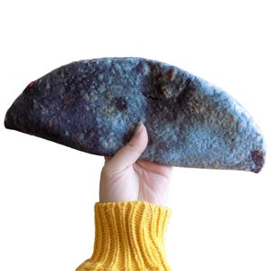 Puede incluir: Una tortilla azul y marrón con una textura moteada.