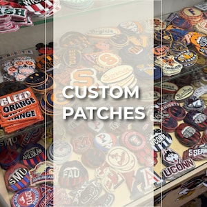 May include: A large collection of embroidered fabric patches featuring various university logos, sports team emblems, and text designs like Bleed Orange and UCONN, displayed in stacks on shelves with the text CUSTOM PATCHES overlaid in white.