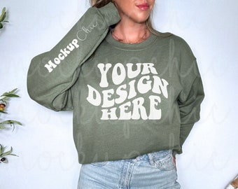 May include: A green sweatshirt with long sleeves and a crew neck. The sweatshirt has the text "YOUR DESIGN HERE" printed on the front in a white retro font.