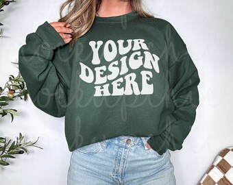 May include: A dark green sweatshirt with the text "YOUR DESIGN HERE" in a white retro font.