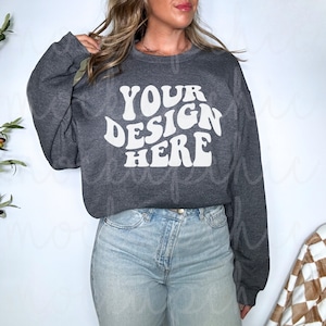 May include: A dark gray sweatshirt with the text "YOUR DESIGN HERE" in a retro, white font.