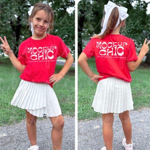 Könnte beinhalten: Ein rotes T-Shirt und ein weißer Faltenrock. Das T-Shirt hat den weißen Schriftzug "MOCKUP CHIC" und den Text "NO AI Real Models & Real Apparel". Der Rock ist weiß und hat Falten.