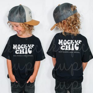 以下が含まれることがあります： 黒いTシャツとトラッカーハットをかぶった子供。Tシャツには白い文字で「MOCKUP CHIC」と書かれており、その下に「REAL MODELS & REAL APPAREL」と書かれています。帽子はグレーとタンです。