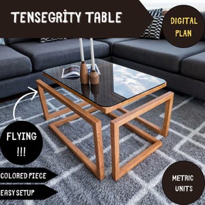 May include: A wooden table with a glass top, featuring a unique design where the legs appear to float. The table is made of natural wood and has a modern, minimalist aesthetic. The text "TENSEGRITY TABLE" is displayed above the table, and "DIGITAL PLAN" is displayed in the top right corner. The text "FLYING!!!" is displayed in the bottom left corner, and "METRIC UNITS" is displayed in the bottom right corner.