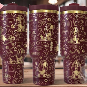 以下が含まれることがあります： 金色のデザインが施された、マルーン色のステンレス製のタンブラー。バセットハウンド、骨、犬関連のアイテムが繰り返しパターンで描かれています。タンブラーには蓋とハンドルが付いています。