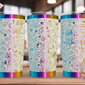 May include: Three stainless steel tumblers with a rainbow iridescent finish. Each tumbler features a white background with a colorful pattern of dogs, bones, and dog-related items. The text "Woof" is visible on the tumblers.
