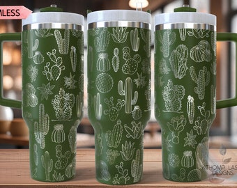 May include: Three green stainless steel tumblers with a white cactus pattern. The tumblers have lids and handles. The text "SEAMLESS" is visible in the top left corner of the image. The text "KATHOMP LASER DESIGNS" is visible in the bottom right corner of the image.