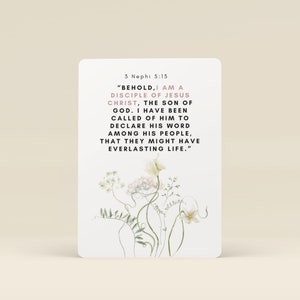 May include: A white card with a floral design on the bottom half. The top half features a quote from the Book of Mormon, 3 Nephi 5:13, "BEHOLD, I AM A DISCIPLE OF JESUS CHRIST, THE SON OF GOD. I HAVE BEEN CALLED OF HIM TO DECLARE HIS WORD AMONG HIS PEOPLE, THAT THEY MIGHT HAVE EVERLASTING LIFE."