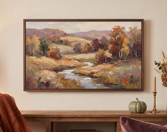 May include: A rectangular landscape painting in a dark wood frame featuring an autumn scene with a winding stream, rolling hills, and trees with orange, yellow, and brown foliage. The artwork displays visible brushstrokes and a muted color palette.