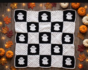 May include: A crochet blanket featuring a checkerboard pattern of black and white squares, with white ghost motifs appliqued onto the black squares. The text "EASY GHOST GRANNY SQUARE PATTERN" is displayed in a bold font at the top of the image.