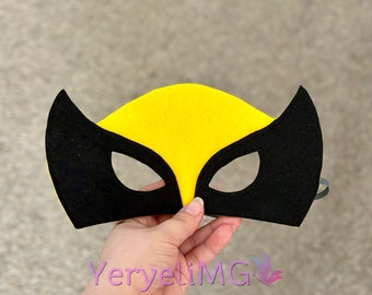May include: A black and yellow felt mask with eye holes. The mask has a pointed shape at the top and two pointed shapes on the sides.