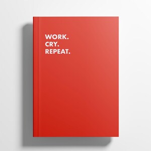 Könnte beinhalten: Ein rotes Notizbuch mit dem weißen Text "WORK. CRY. REPEAT.". Das Notizbuch hat einen festen Einband und ein schlichtes, modernes Design. Der Einband ist in einem leuchtenden, einfarbigen Rot gehalten.