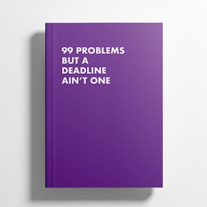Op de afbeelding: Een paars notitieboek met de witte tekst "99 PROBLEMS BUT A DEADLINE AIN'T ONE". Het rechthoekige notitieboek heeft een eenvoudig ontwerp, ideaal voor notities of het bijhouden van een dagboek.