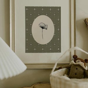 May include: A framed print of a black and white drawing of a single flower in a circular frame against a green background with a repeating diamond pattern.