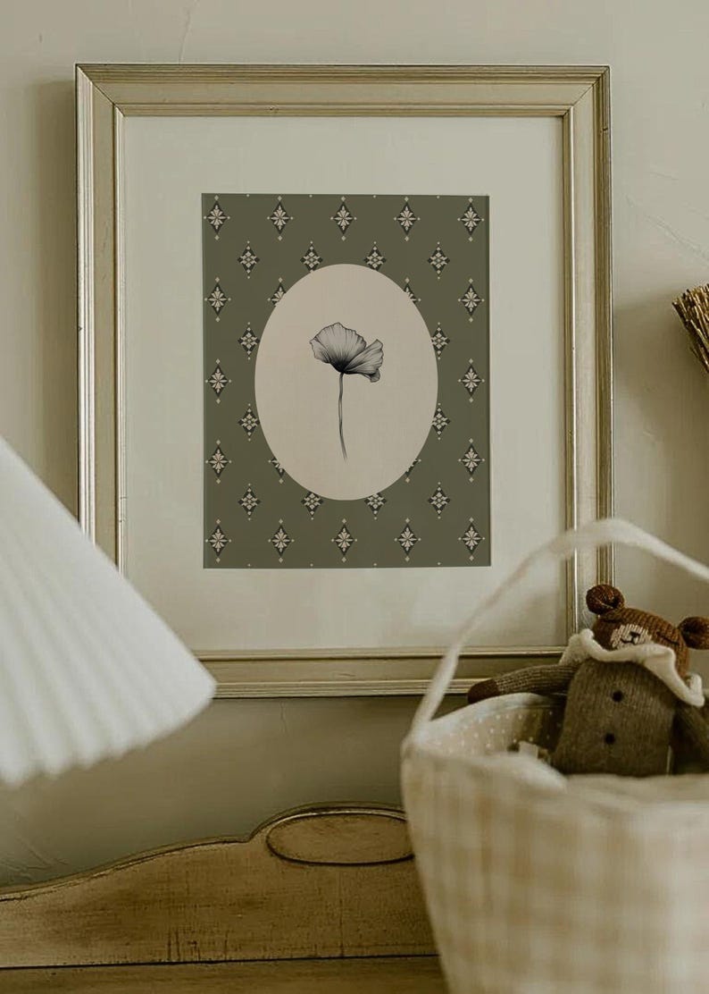 May include: A framed print of a black and white drawing of a single flower in a circular frame against a green background with a repeating diamond pattern.