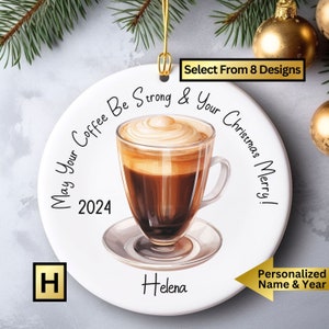 May include: White round Christmas ornament with a coffee cup illustration and the text "May Your Coffee Be Strong & Your Christmas Merry! 2024". The ornament is personalized with the name "Helena".