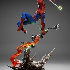 May include: A dynamic figurine of Spider-Man in a red and blue suit, mid-air, grasping a weapon. The base features a Green Goblin glider with orange and green energy effects, and a smoky, rocky base. The overall theme is action and superhero.