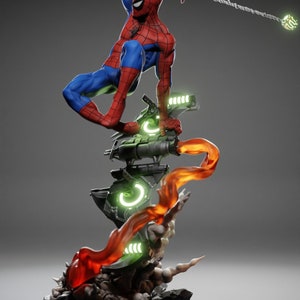 May include: A detailed figurine of Spider-Man in a dynamic pose, clad in his signature red and blue suit. The figure is mounted on a futuristic base with glowing green and orange accents, and a web line extends from his hand.