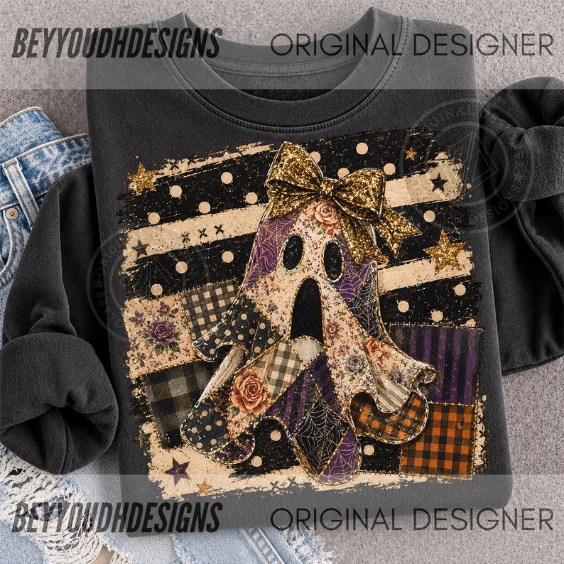 May include: A dark grey sweatshirt featuring a central graphic of a ghost adorned with a large gold glitter bow. The ghost is composed of various patchwork patterns including floral prints, black and orange plaid, purple stripes, and spider webs.