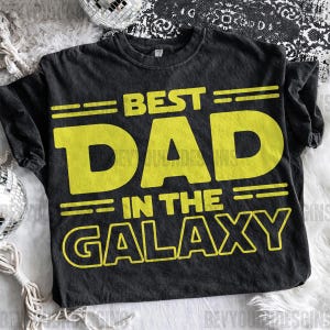 Puede incluir: Camiseta negra con la frase "BEST DAD IN THE GALAXY" en amarillo. Un dise&ntilde;o divertido y juguet&oacute;n, perfecto para un regalo. La camiseta es suave y c&oacute;moda.