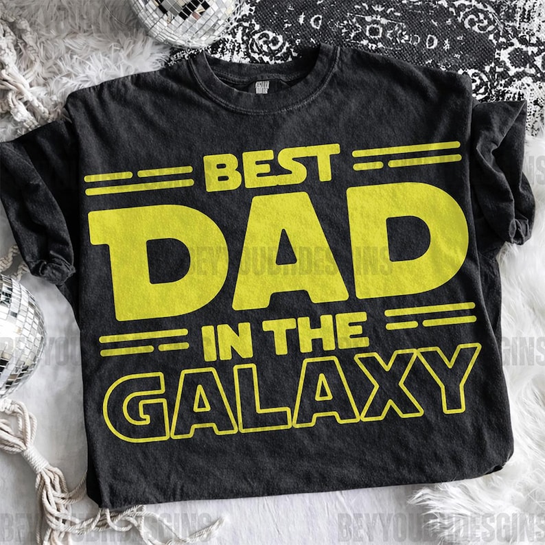 Puede incluir: Camiseta negra con la frase "BEST DAD IN THE GALAXY" en amarillo. Un dise&ntilde;o divertido y juguet&oacute;n, perfecto para un regalo. La camiseta es suave y c&oacute;moda.