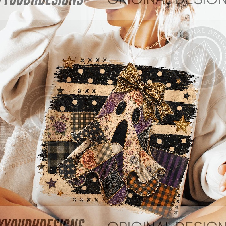 May include: A cream-colored sweatshirt featuring a central graphic of a ghost adorned with a gold glitter bow. The ghost is composed of various patchwork patterns including floral, plaid, and spiderweb designs, set against a black and white background.