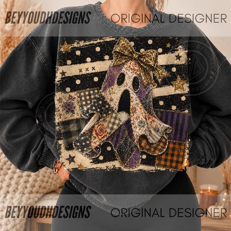 May include: A charcoal grey crewneck sweatshirt featuring a central graphic of a ghost adorned with a gold glitter bow. The ghost is composed of various patchwork patterns including plaid, floral, and spiderweb designs against a striped background.