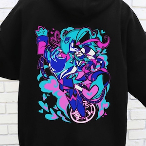 May include: Black hoodie featuring a vibrant graphic on the back. The design showcases a stylized anime-inspired character in shades of blue, pink, and purple, surrounded by hearts and swirls. The hoodie has a drawstring hood and long sleeves.