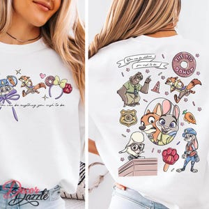 May include: White sweatshirt featuring colorful cartoon characters and the text "You can be anything you wish to be." The back of the shirt has more cartoon characters and the words "THE BIG DONUT."