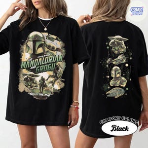 May include: Black t-shirt featuring a graphic design from the Star Wars series, "The Mandalorian and Grogu." The front of the shirt displays the title and characters, while the back showcases additional imagery. The text "This is the Way" is also visible.