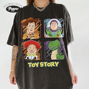 May include: Dark gray Comfort Colors t-shirt featuring four Toy Story characters: Woody, Buzz Lightyear, Jessie, and Rex. The words "TOY STORY" are printed in yellow below the characters. The shirt has a vintage, worn look.