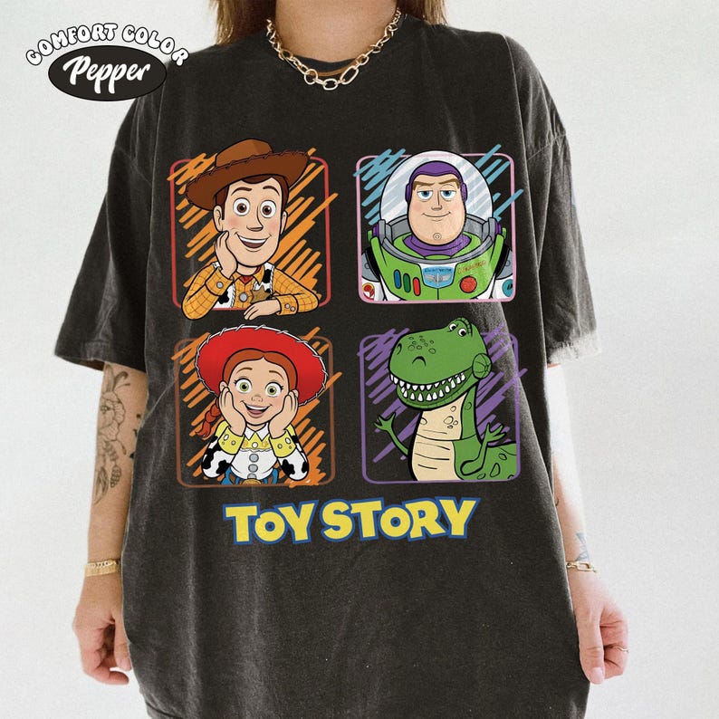 May include: Dark gray Comfort Colors t-shirt featuring four Toy Story characters: Woody, Buzz Lightyear, Jessie, and Rex. The words "TOY STORY" are printed in yellow below the characters. The shirt has a vintage, worn look.