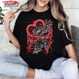Puede incluir: Camiseta negra con un dise&ntilde;o gr&aacute;fico rojo y gris. El dise&ntilde;o incluye una forma de coraz&oacute;n, figuras abstractas y el texto "FAST DELIVERY" en la esquina superior izquierda. La camiseta es de material suave.
