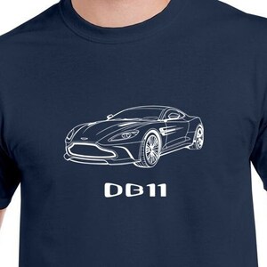 Peut inclure: Un t-shirt bleu marine avec un contour blanc d'une voiture Aston Martin DB11 et le texte "DB11" imprimé sur le devant.