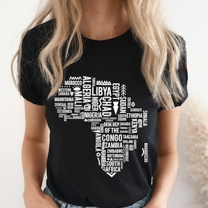 May include: Black t-shirt with a white graphic of the African continent, filled with country names. The shirt has a crew neck and short sleeves. Countries like Morocco, Nigeria, and South Africa are visible.
