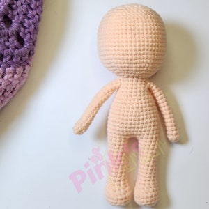 May include: A peach-coloured, crocheted doll body with a rounded head, arms, and legs. The doll is made with a tight stitch pattern, suggesting a sturdy construction. The body is designed to be a base for a handmade doll.