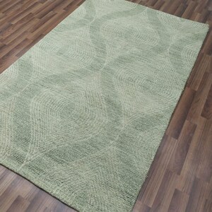 May include: A green area rug with a wavy, abstract pattern. The rug has a soft, plush texture.