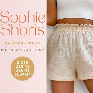 May include: Cream-coloured paperbag waist shorts with a ruffled waistband and a relaxed fit. The image includes text: "Sophie Shorts", "Paperbag Waist", "PDF Sewing Pattern", and size information for UK and EU sizes.