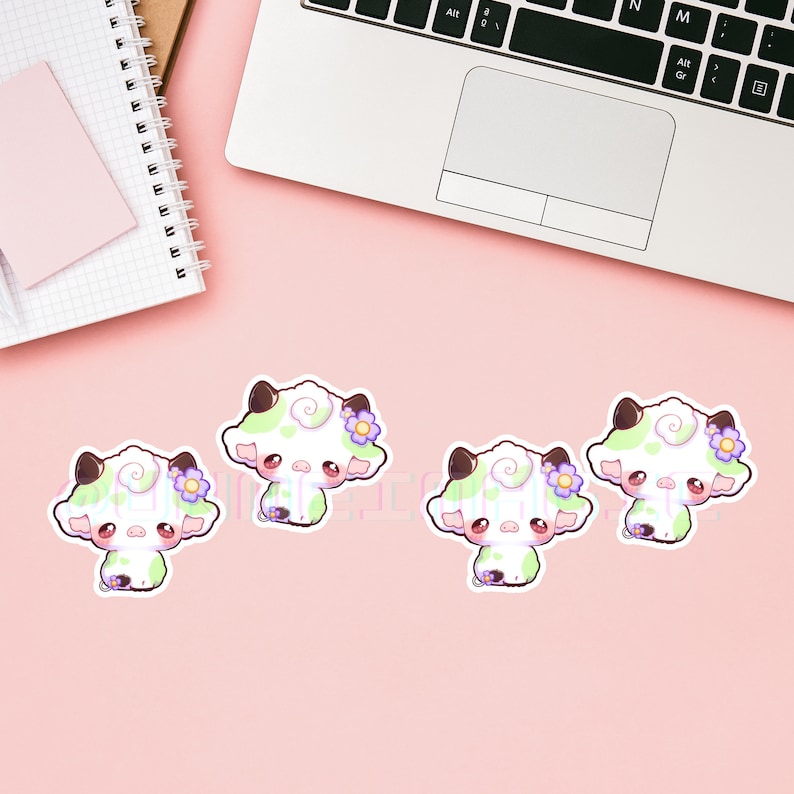 Puede incluir: Cuatro pegatinas de vaca blancas y verdes con flores moradas. Las pegatinas est&aacute;n sobre un fondo rosa.