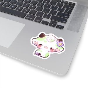Puede incluir: Una ilustraci&oacute;n de dibujos animados de una vaca blanca con manchas verdes y una flor morada en la cabeza. La vaca tiene ojos grandes y redondos y una nariz rosa.
