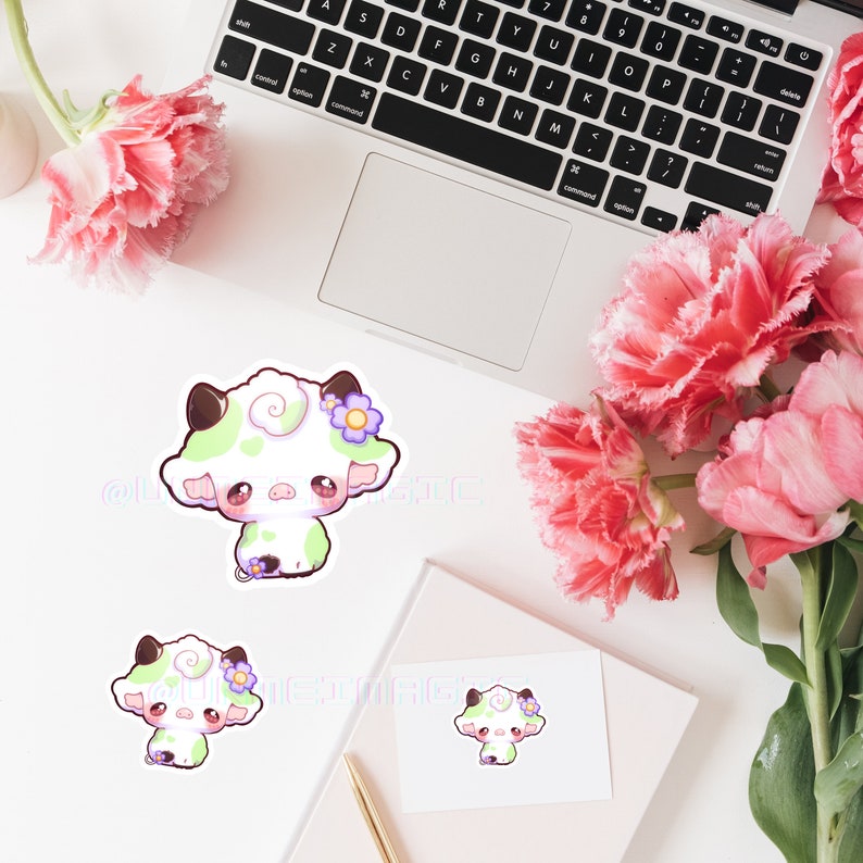 Puede incluir: Tres adorables pegatinas de vaca de dibujos animados con manchas verdes y blancas, mejillas rosadas y flores moradas. Las pegatinas est&aacute;n sobre un fondo blanco.