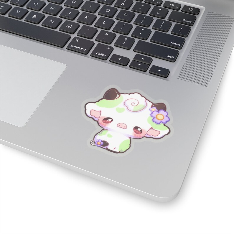 Puede incluir: Una ilustraci&oacute;n de dibujos animados de una vaca blanca con manchas verdes y una flor morada en la cabeza. La vaca tiene mejillas rosadas grandes y est&aacute; mirando hacia un lado.